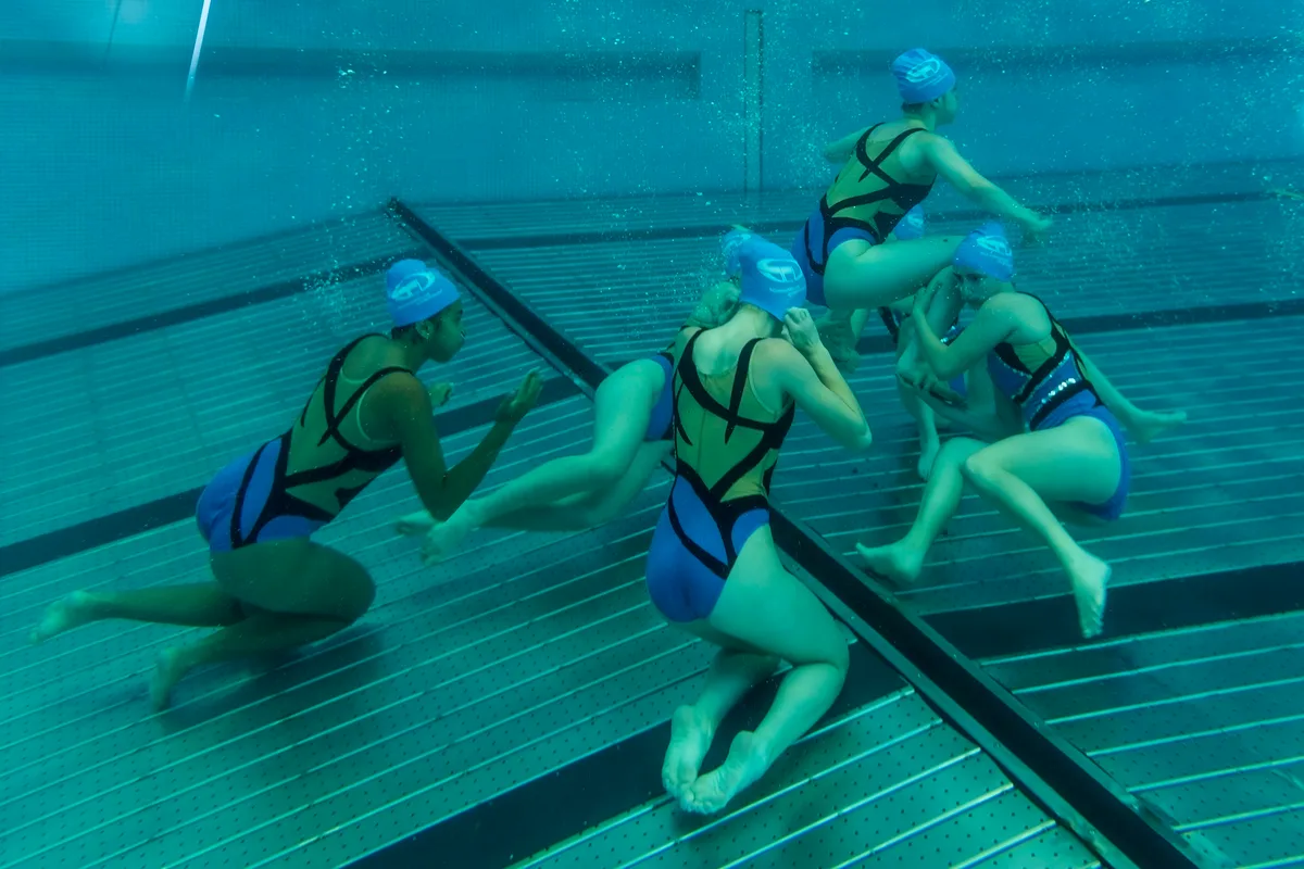 Synchronschwimmerinnen unter Wasser.